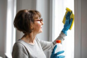 A woman cleaning the window - Quality Home Products of Texas