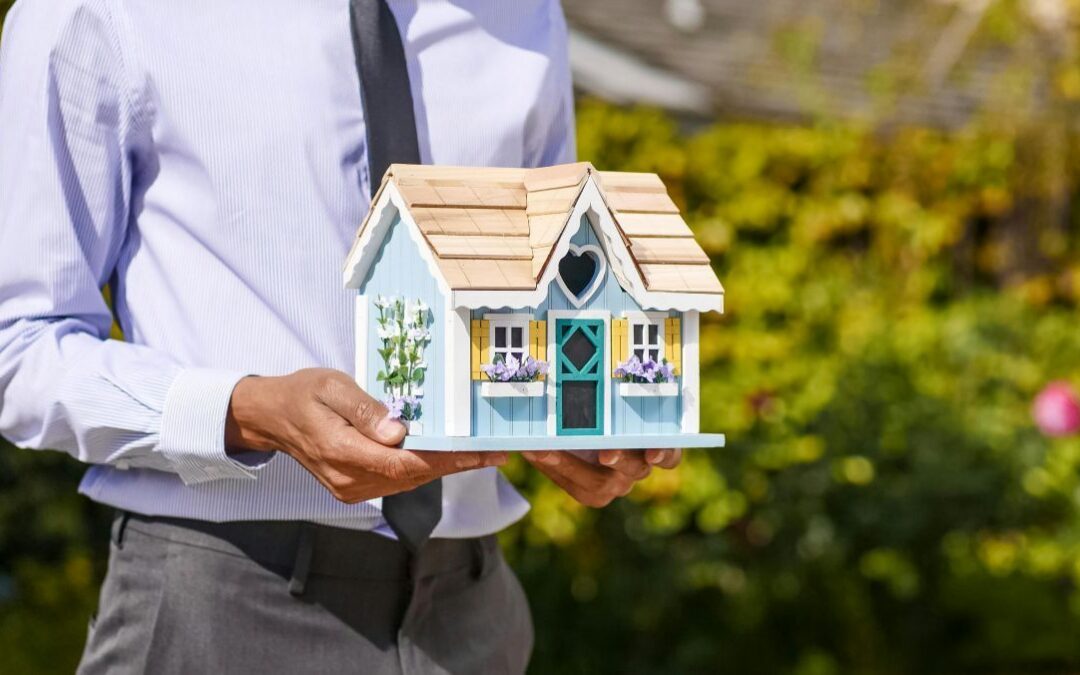 A man holding a wooden house