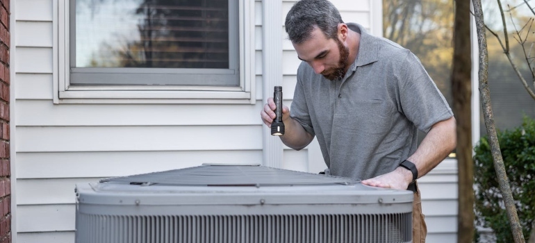 a man checking an HVAC unit