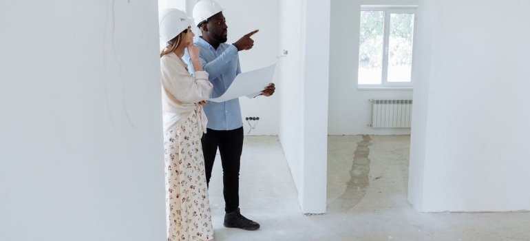 a man and a woman checking the house under construction